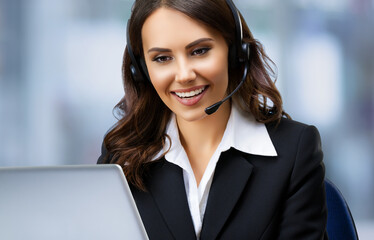 Call center. Customer support sale operator in headset. Businesswoman or phone worker looking at laptop computer, inside. Answering service agent, blurred office background. Online video conference.