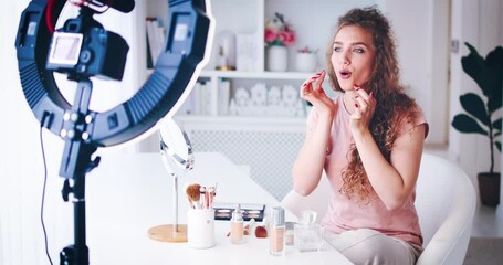 young woman streaming a beauty vlog from home, online content creator applying a makeup on, video tutorial