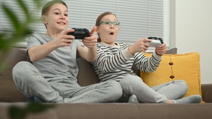 Excited brother and sister playing video game