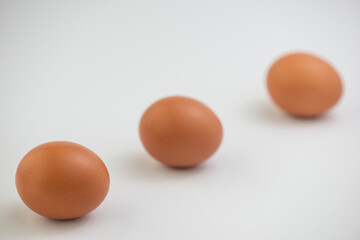 Closeup of fresh brown eggs over white background