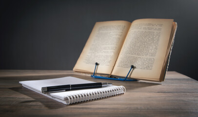 Pen, notepad and book on the table.