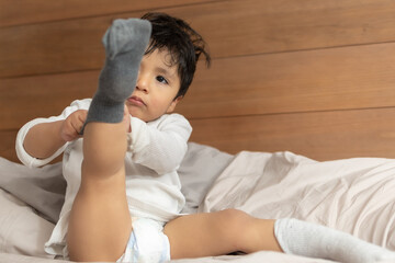 Mexican 2 years old baby putting on socks wrong