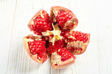 cut pomegranate fruit close-up on a white wooden table