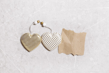 Valentines day concept. Soft toy hearts from linen cloth with gold color striped or dots on marble background. Valentine as torn paper craft with empty space. Paper mock up for text love message