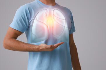 Man holding hand near chest with illustration of lungs on grey background, closeup