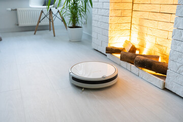 Modern robotic vacuum cleaner on floor in living room. Space for text