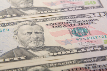 Obraz na płótnie Canvas Fragments of fifty dollar bills on a flat surface, very close-up.