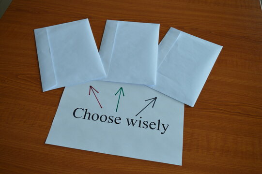 concept photo, three white envelopes on the office desk with the message choose wisely, making business and life decisions