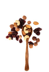 A mixture of shelled nuts and cranberries on a wooden spoon and a white background.