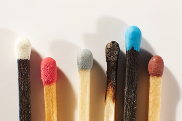 A Few wooden matches with colorful heads on a light gray background close-up. Matchsticks without box.