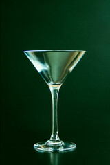 Empty martini glass on a green background. vertical photo