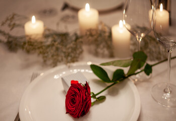 romantische Atmosphäre beim candlelight-dinner mit roter Rose und kleinem Geschenk