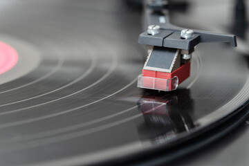 Fototapeta na wymiar Closeup of vintage record player while playing a vinyl record. Black platter