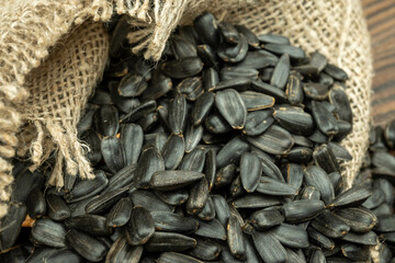 Sunflower seeds are scattered on homespun fabric with a rough texture. close-up, selective focus.