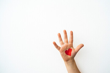 Little kid hand with red heart drawn on white background with copy space. 