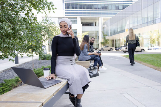 Black business executive wearing hijab working in city plaza