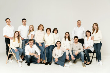Fototapeta premium portrait of a large family on a white background. a large friendly family is dressed in red and black clothes. a group of people from different regions of the country. people of different ages