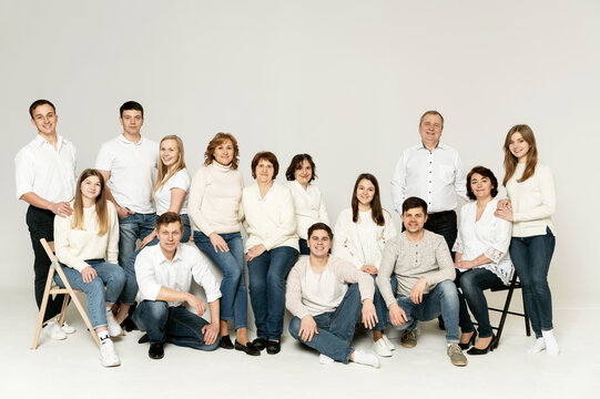 portrait of a large family on a white background. a large friendly family is dressed in red and black clothes. a group of people from different regions of the country. people of different ages