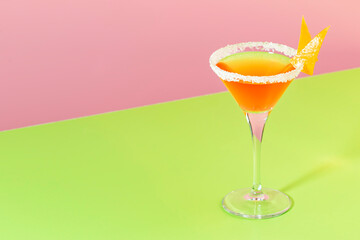 Sidecar alcoholic cocktail with cognac, liqueur, lemon juice and ice. Pink and green background, copy space
