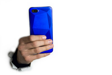 The hand holds the phone on a white background and takes pictures.