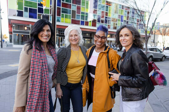 Portrait Happy Mature Women Friends On City Street Corner