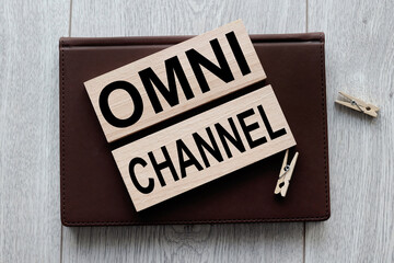Obraz premium OMNI CHANNEL text on wooden blocks on notepad on wooden background