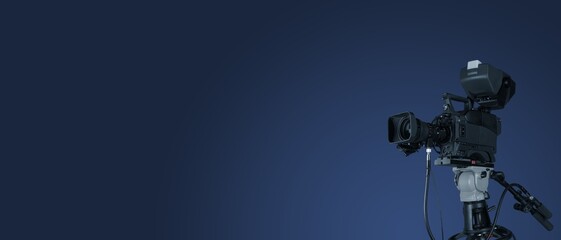 Digital film camera in the dark wall background. Video camera for film production,