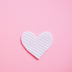 White fabric heart on pale pink table