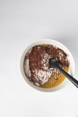 Making brownies in a white bowl, ingredients for making brownies in a white bowl, brownie batter in a bowl