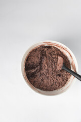 Brownie batter in a white bowl, Making brownies in a white bowl, folding ingredients for making brownies with a black spatula