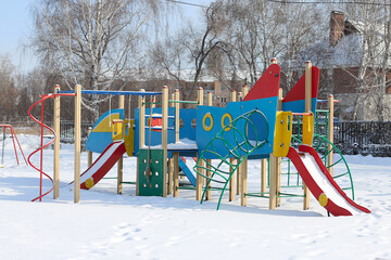 children's play complex playground with slides and stairs in the winter park