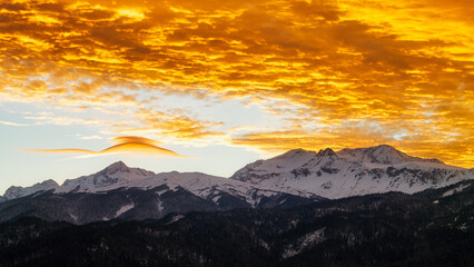 Beautiful scarlet clouds sunset in the winter mountains