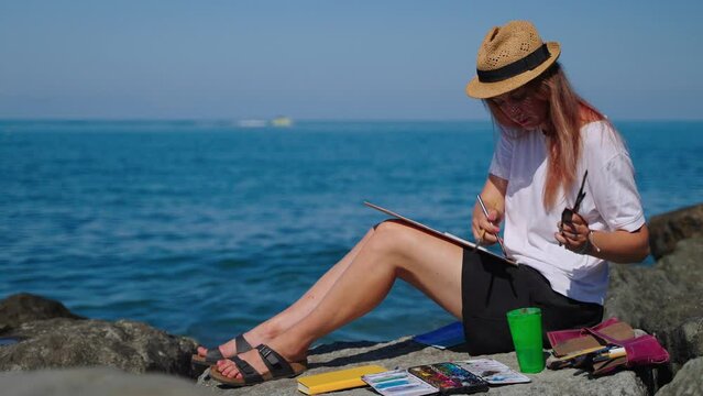 Woman relaxing with painting near the sea