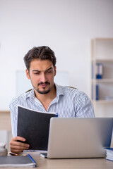 Young male employee and too much work in the office