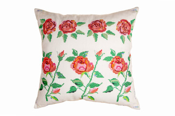 Cross-stitch embroidery in the form of roses on a white linen pillow, close-up.