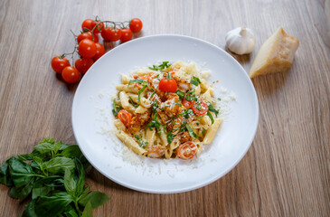 Penne pasta with breadcrumbed chicken breast, cheese, spring onion and tomato angle view