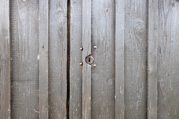 Verwitterte Holztür eines Schuppens mit Schloss