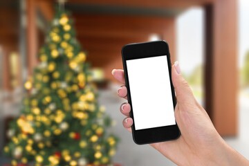 Hand hold modern phone with empty mockup screen on Christmas holidays.