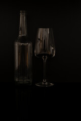 Black background and glass bottles with reflection on table