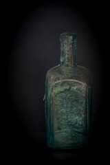 Black background and glass bottles with reflection on table