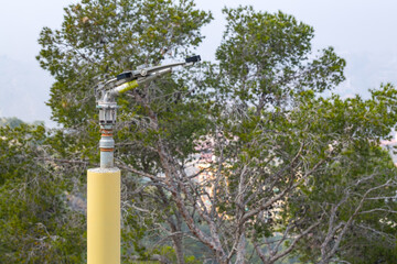 Fototapeta premium Fire sprinkler with a nozzle valve incorporated. An heavy-duty part of the fire protection system of forest or park green flammable plantations in areas with dry and hot climates. Alicante. Spain.