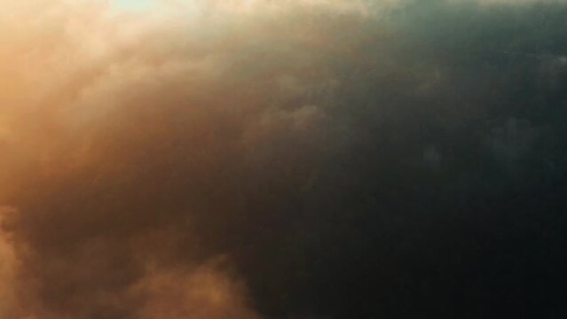 Aerial shot above the clouds of mountains covered with trees in Murree,Pakistan