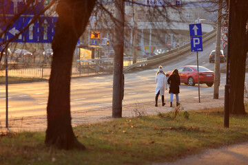 Dwie dziewczyny spacerują chodnikiem wzdłuż drogi we Wrocławiu. - obrazy, fototapety, plakaty
