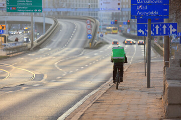 Kurier jedzie na rowerze we Wrocławiu, dostarcza jedzenie.  - obrazy, fototapety, plakaty
