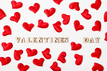 Red hearts and the inscription Valentine's Day on a white background. Lovers' holiday concept, greeting card.