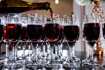Many glasses filled with red wine close-up, drinks, bright background.