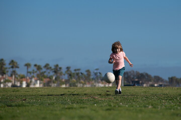 Obraz na płótnie Canvas Boy child playing football on football field. Kid playing soccer. Kids training soccer.