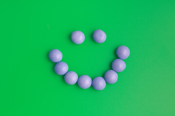 A purple candy smile on a bright green background