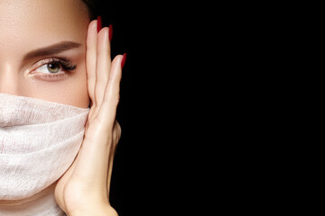 Beautiful woman with bandage mask on face. Fashion eye make-up. Beauty surgery or protection...