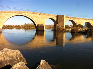 Fototapeta na wymiar Reflejo de puente en río